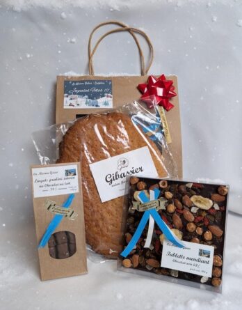 présentation d'un coffret pour noel avec un sac cadeau, un gibassier, une tablette mendiant, et des lingots praliné de la maison griess
