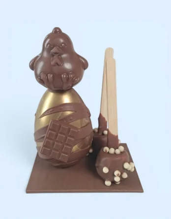 montage de pâques en chocolat au lait avec un oeuf, un poussin et deux sucettes guimauves au chocolat au lait de la maison griess