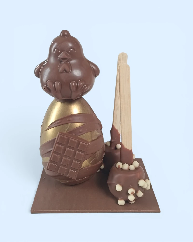 montage de pâques en chocolat au lait avec un oeuf, un poussin et deux sucettes guimauves au chocolat au lait de la maison griess